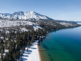Snowy beach and piers on calm Lake Tahoe. Cascade, South Lake Tahoe, California, United States of America.
