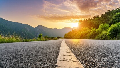 Low level view of empty old paved road in mountain area at sunset