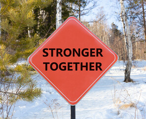Stronger together symbol. Concept words Stronger together on beautiful red road sign. Beautiful forest snow blue sky background. Business, motivational and stronger together concept.