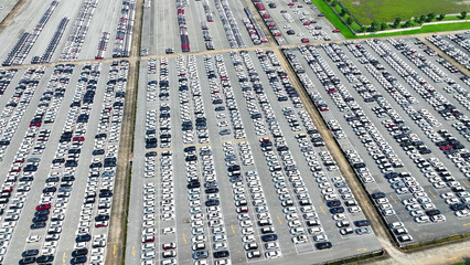 From above, a drone reveals a mesmerizing sight: a row of brand-new cars for sale, lined up like gems on display. Automotive industry: Innovating mobility, powering progress. Automotive industry.
