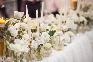 Wedding decor. Close up of a wedding table decoration with white and pink flowers and candles. Wedding floristic concept