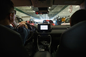 Couple driving the car on to a ferry. Unrecognizable worker checking the cars in front. Seattle....