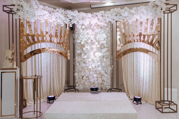 A wedding reception with a white archway and a white wall. Scene is elegant and romantic