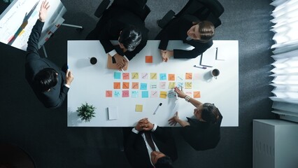 Top down aerial view of manager standing and present marketing plan to skilled investor. Diverse...