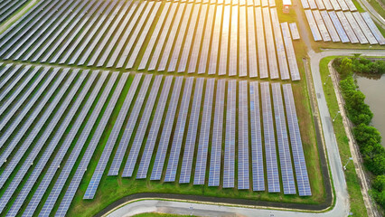 A breathtaking aerial view of a vast solar power plant, rows of glistening panels stretching to the horizon, harnessing the sun's energy. Green power: Nature's endless energy.
