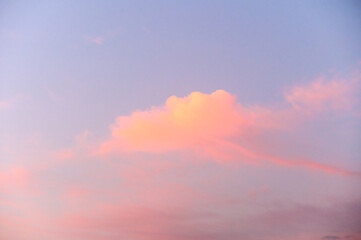 Obraz premium Light pink clouds in sunset blue sky.