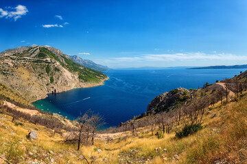 Panoramic view of the Adriatic seacoast surrounded by Dinara mountains, Dalmatia, Croatia. Scenic landscape with sea, rocks and blue sky, outdoor travel background