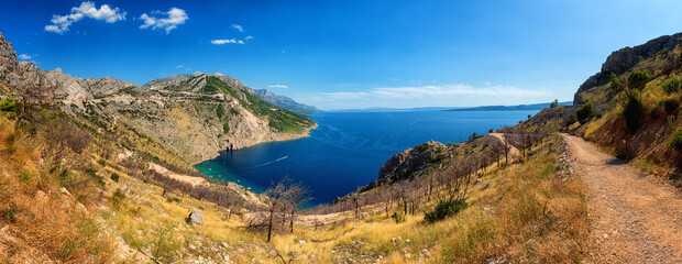Panoramic view of the Adriatic seacoast surrounded by Dinara mountains, Dalmatia, Croatia. Scenic landscape with sea, rocks and blue sky, outdoor travel background