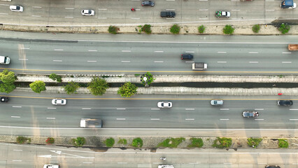 Amidst the intercity motorway's hustle, a drone reveals a rhythmic dance of cars. In the midst of...