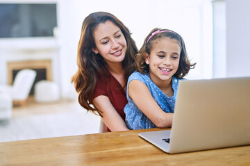 Happy, mother and young girl with laptop for remote education, learning and child development at home, Excited, mom and kid with computer on table for study, homework and teaching motor skills