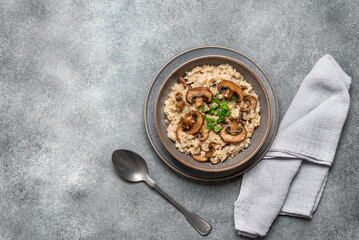 Risotto with mushrooms on a gray grunge background. Italian dish. Top view, flat lay, copy space.