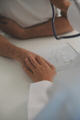 Obraz premium Young doctor is using a stethoscope listen to the heartbeat of the patient. Shot of a female doctor giving a male patient a check up