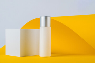 Plastic white tube for cream or lotion. Skin care or sunscreen cosmetic with stylish props on...