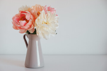 Beautiful fresh colorful peony flowers in full bloom in vase. Copy space for text. Floral still...