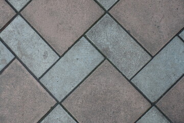 Closeup of geometric pavement made of grey and brown concrete tiles
