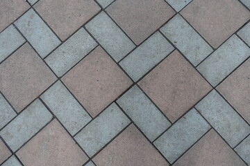 View of geometric pavement made of grey and brown concrete tiles from above