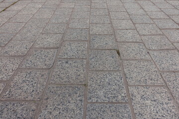 Closeup of pavement made of gray unpolished granite stone blacks