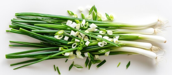 Pile of sliced scallions placed on a white background, seen from above