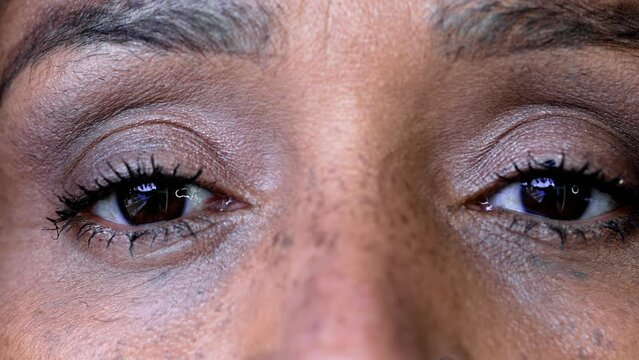 Macro close-up detail of African American 50s woman looking at camera tight eye