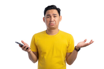 Handsome young Asian man holding mobile phone and shrugging his shoulders with confused expression isolated on white background