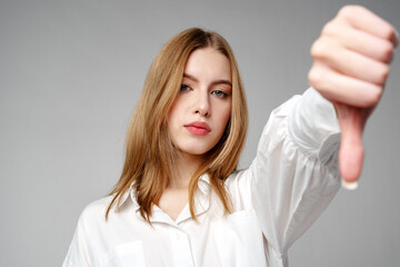 Young Woman in White Shirt Pointing Finger Down Dislike