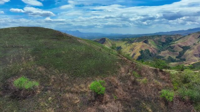 Aerial panorama of mountain landscape with path during sunny day in South Philippines. Wide shot.