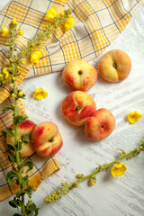 Several whole saturn peaches or flat peach on white wooden background..