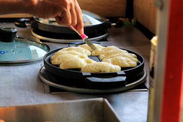 pukis cake making. Pukis is made of a wheat flour-based batter and cooked in a special mold pan