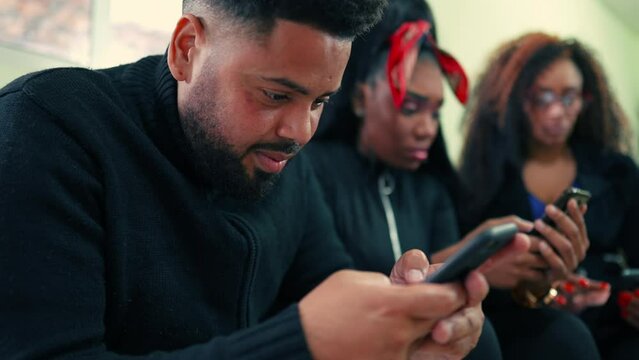 People typing message on phones. Close-up of African American young man texting and using modern technology to communicate in modern era, people absorbed by their smartphones