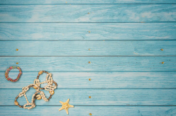 Shell jewelry on a blue wooden background. Top view, copy space