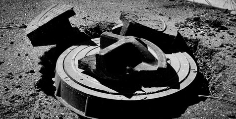 Manhole cover. Abstract grunge background. Black and white photo. Utilities concept. Two manhole...