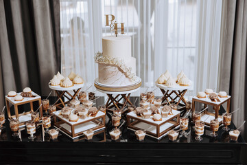 A table with a white cake and a couple of other cakes with the letters P and H on them