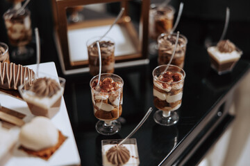 A table full of desserts, including a variety of cakes and pastries, is set up for a party