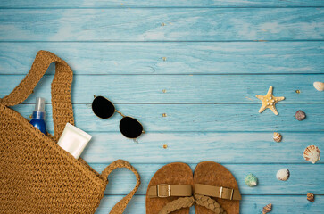 Beach accessories with sea shells on a blue wooden background. Top view, copy space