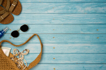 Beach accessories with sea shells on a blue wooden background. Top view, copy space