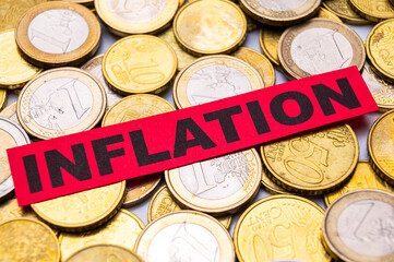 Background of Euro coins, and red ticket with text Inflation.