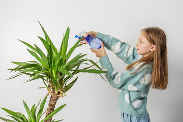 Focused Child Girl Watering Plant with Blue Sprayer