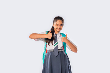 Portrait of cheerful Indian asian teenage schoolgirl with school uniform and backpack