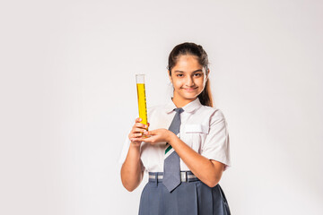 Indian asian small school girl in uniform holding flask with chemical against white background