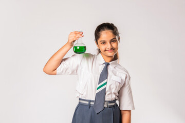 Obraz premium Indian asian small school girl in uniform holding flask with chemical against white background