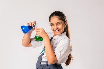 Indian asian small school girl in uniform holding flask with chemical against white background