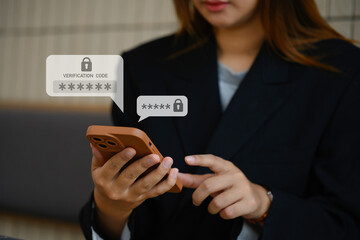 Young businesswoman typing on smartphone entering verification code for login. Cyber security concept