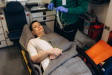 Ambulance car interior. Emergency medical service equipment. Patient on a stretcher receiving first...