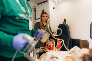 Portrait of a female doctor with a patient in the middle of an ambulance