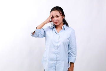 Bothered and tired asian woman, looking complicated, touching forehead, face palm sign, looking distressed at camera, white background