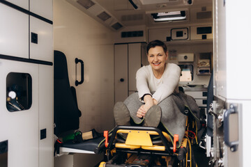 Portrait of a happy woman in the middle of an ambulance