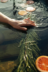 A hand splashes in a fragrant vat of citrus