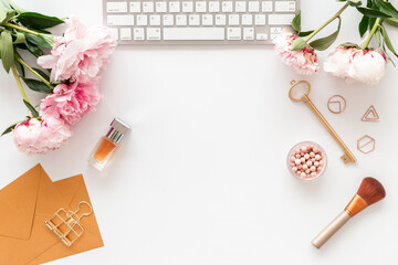 Flatlay office desk with pink peony flowers and female accessories