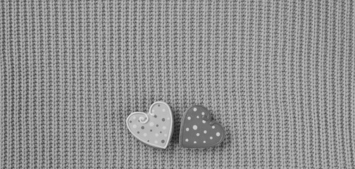 Cozy Comfort with a Touch of Love. Two Polka Dot Heart Buttons on a Knitted Grey Sweater