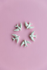 Five white swallows on pink background